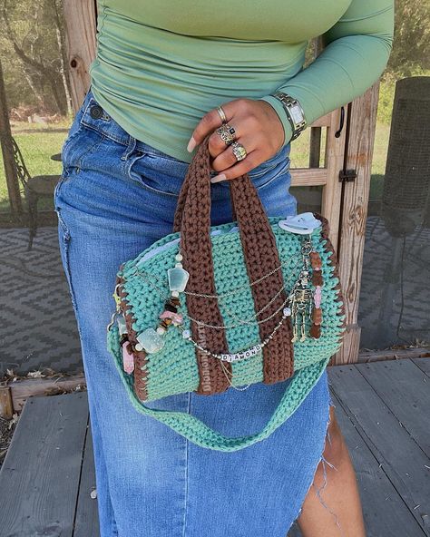 Crochet Duffel Bag 🧚🏽‍♂️ I love this little crochet duffle bag so much 😭 yall have no idea. It took me a bit longer to make it but it was 100% worth it for sure. It’s the size of a handbag. You could take it with you traveling or have it for everyday use. The pattern is simple enough that you could definitely alter it and make it bigger or even smaller. It fits sooo much stuff tho. I included a video clip of a “what fits in my bag” video I did. It cut out but I also had a whole sketchbook ... Crochet Duffel Bag, Crochet Duffle Bag, Crochet Bag Outfit, Vendor Stand, Crochet Fits, Pool Shoot, Duffle Bag Patterns, Bag Video, Crochet Bag Pattern Free