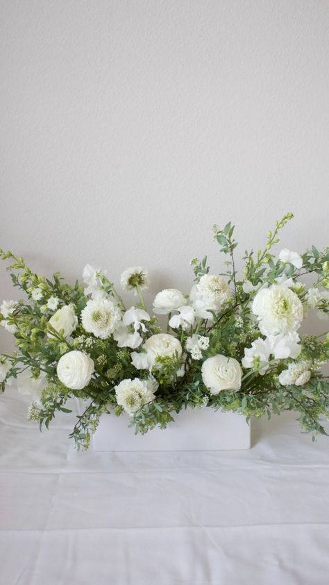 white ranunculus, sweet peas, scabiosa, larkspur, greenery, white rectangle vessel. table arrangement Scabiosa Bouquet, White Scabiosa, Ceremony Florals, White Floral Arrangements, Flower Installation, Bride Magazine, Sweet Peas, Floral Inspiration, Brides Magazine