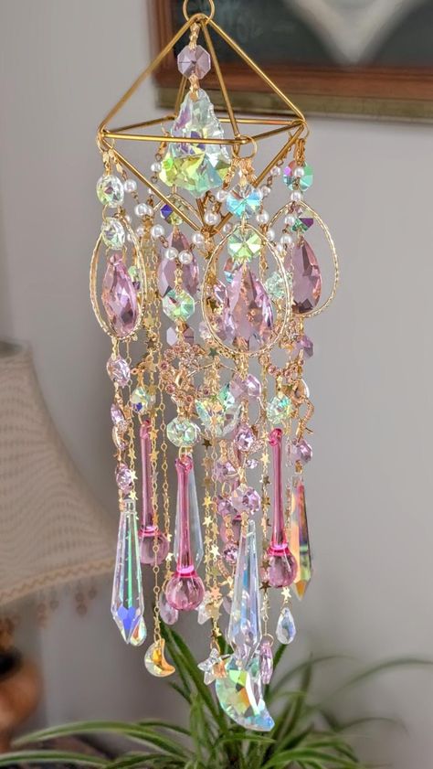 Mama Crystal Suncatcher Unique, one of a kind Size of the ornament: each side 2.6" Long and 3.75"total Total with golden chain (hook included) approx. 26.5"L 4 Golden Rings Drops: about 60mm long, 41mm wide 4 Crystal chandelier Pastel Pink pendants : 38mm 4 Crystal AB Iridescent Icicles: 76mm 4 Crystal Pink Raindrops: 80mm 1 Crystal Prism AB Pendant: 50mm 1 Crystal Moon AB Iridescent: 45mm 5 Flower Zircon Pendants Pink: approx. 30mm 4 Gold Plated Moon Crescent Charms: 31/25mm 1 Crystal Heart AB: 26mm in Golden Geometric Circle  Crystal Octagons: AB and Pink 8 Crystal Teardrops/Moon/Stars: AB/Pink Golden stars chain Beaded Pearl Chain: Gold Nickel Free Iron Golden Chain