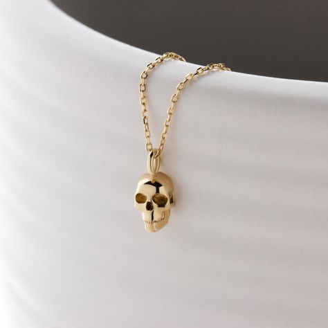 This minimalist skull pendant is a symbol of fearless spirit and individuality. Its sleek and simple lines make it a versatile accessory that blends seamlessly with both modern and classic wardrobes. The 14k solid gold construction ensures lasting beauty and a luxurious feel that will enhance any ensemble it accompanies. Perfect as a daily reminder of strength and resilience, a statement of personal empowerment and style. * Please let me know your different chain length or 14k White Gold requests via Etsy message. ✈️ Enjoy our FREE EXPRESS SHIPPING advantage with a timely, smooth delivery. We ship within 1-3 business days of receiving your order. So you can have your order in your hands as soon as possible. With fast and efficient shipping, you can rest assured that your gift will arrive o Luxury Skull Necklace For Gift, Luxury Gold Skull Jewelry, Vintage Skull Necklace For Gift, Gold Skull Necklace, Vintage Gold Skull-shaped Jewelry, Skeleton Necklace, 20 Inch Necklace, Unusual Necklace, Modern Gold Jewelry