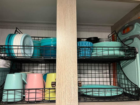 I love how this rv pantry is organized - all in wire bins with sides! You can see through them so you don't lose stuff, and it's also way easier to secure a wire bin vs stack of plates! Camper Plate Storage, Camper Pantry Storage Ideas, Rv Plate Storage Ideas, Rv Silverware Storage Ideas, Camper Cabinet Organization, Camper Pantry Organization, Camper Bathroom Storage, Rv Pantry Organization, Camper Organization Ideas