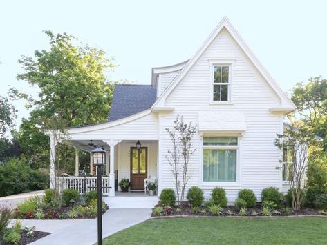 Location: Bentonville, AR Built in: 1904 Size: 3,200 sq. ft. Paint colors: (house) White Dove, Benjamin Moore "It was our dream to restore an old home," say homeowners Shelley and Kevin Kraning. They love the original details like the diamond-patterned shingles on the awning over the window and the lamppost. A front-facing gable is a common feature of Folk Victorians like this one. The Kraning's found ornate corbels at a local flea market; even though they aren't orginal, they look right at h Antique White House Exterior, Gable Pediment, White Shingle House Exterior, Victorian House Exterior, Cottage Exterior Ideas, White Victorian House, Shingle House, White Siding, Brick Path