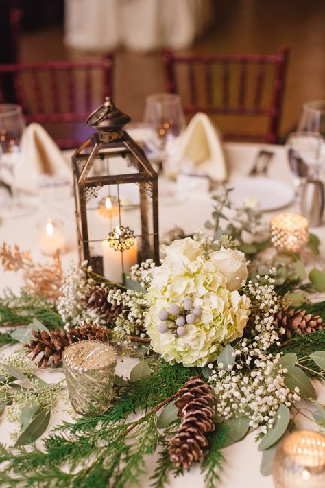 Katie warmed up her winter wedding decor with lanterns and candelabras on every table. The centerpieces also incorporated flowers from her bouquet, like hydrangeas, baby's breath, and pinecones. Pinecone Wedding Decorations, Winter Table Centerpieces, Christmas Wedding Centerpieces, Winter Table Decorations, Winter Wedding Table, Winter Wedding Centerpieces, Winter Centerpieces, Boda Diy, Wedding Adventure