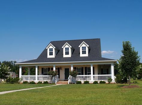 White farmhouse with wrap-around porch and dark gray roof with three white dormer windows prominently jutting out from the long sloping roof. House With Dormers, House With Wrap Around Porch, Dormer House, Dormer Roof, Big Porch, Black Roof, Cape Cod Style House, Foreclosed Homes, Suburban House