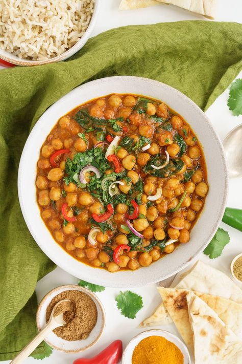 Bowl of vegan chickpea curry on the table with ingredients and a green napkin. Vegan Curry Recipes Chickpeas, Healthy Vegetarian Meal Prep, Chickpea Curry Meal Prep, Hungry Root, Chickpea And Kale Curry, Quick Chickpea Curry, Chickpea And Spinach Curry, Vegan Chickpea Curry, Healthy Protein Meals