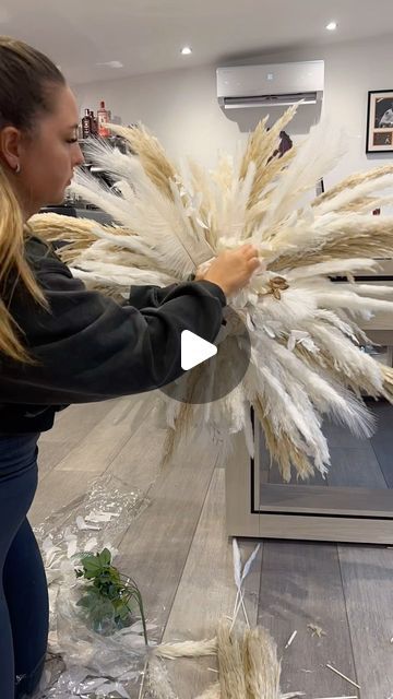 Decor Me Pampas on Instagram: "Work in progress 🎥  In loooove with this pampas display for @muabrooklyn_ ☁️   🚫Not for sale. Custom order! 📲DM with your enquiry   #pampas #pampasgrass #pampascloud #pampasgrasswedding #pampasgrassdecor #pampasdecor #pampasdisplay #pampaswalldisplay #salondecor #homedecor #handmade #bespoke #wallfeature #whiteroses #roses #feathers #bunnytails" Diy Pampas Backdrop, Diy Palm Leaves Decor, How To Make A Pampas Grass Arrangement, How To Make A Pampas Grass Swag, Feather Floral Arrangements, Pampas Decoration, Diy Pampas Grass Hanging Arrangement, Feather Decoration Ideas, Pampas Decor