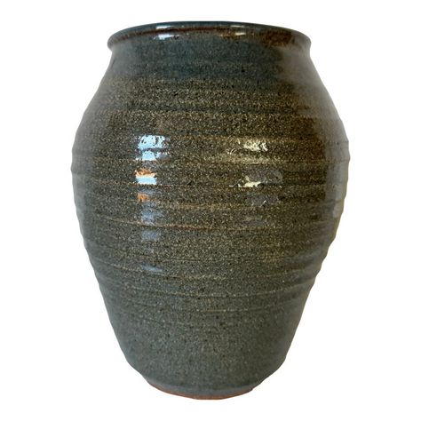 This exquisite vintage studio pottery vase features a deep green glaze with a subtle earthy texture, exuding timeless charm and craftsmanship. The vase’s classic tapered silhouette is enhanced by faint horizontal ridges, a hallmark of skilled wheel-thrown artistry. The reflective glaze captures light beautifully, adding depth to its surface. Signed on the base by the artist, this vase carries a personal touch, making it a unique addition to any collection or decor. Perfect for displaying floral arrangements or as a standalone art piece, it brings an understated elegance to any space. C,1990's.   Measures: 7.0" w x 7.0" d x 9.0" h / Inches   In great Vintage condition with typical wear / marks consistent with age.  Please see all photos for additional details.  Thank You!