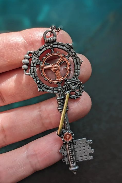 close-up of a hand holding a steampunk key necklace Steampunk Props Diy, Cool Key Designs, Steampunk Symbols, Steampunk Astethic, Diy Steampunk Accessories, Minimalist Steampunk, Steampunk Fashion Diy, Aesthetic Keys, Keys Aesthetic