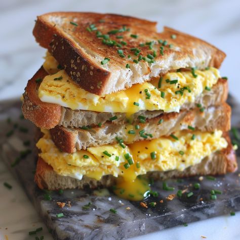 🧀🍳 Experience the ultimate comfort with this Scrambled Egg Grilled Cheese Sandwich! #BreakfastGoals #GrilledCheese Scrambled Egg Grilled Cheese Sandwich Ingredients: Eggs (2) Milk (2 tbsp) Salt and pepper (to taste) Butter (2 tbsp) Bread slices (4) Cheddar cheese (4 slices) Chives (1 tbsp, chopped) Instructions: Whisk eggs, milk, salt, and pepper. Melt 1 tbsp butter in a skillet, scramble eggs until soft, set aside. Butter one side of each bread slice. Place one slice, butter-side down, i... Egg Grilled Cheese Sandwich, Cheese Scrambled Eggs, Tiger Bread, Scramble Eggs, Egg Grill, Cheese Slice, Instagram Recipes, Twisted Recipes, Sandwich Ingredients