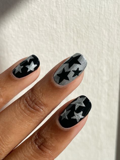 Star black chrome nails. Essie polish (Licorice🖤); Mavala 🩶 polish (Austin). This design works for Christmas and bonfire too Star Nail Manicure, Silver Nails With Black Stars, Gray Star Nails, Short Gel Nails Stars, Black And Silver Star Nails, Bonfire Night Nails, Bonfire Nails, Black Chrome Nail, Chrome Nail Design