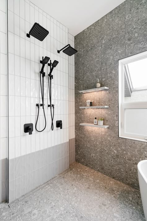 Hella Design Studio | Calgary Interior Design This shower has everything we're looking for! Marble shelves with lighting! A modern look for grey terrazzo shower walls and floor! Black his and hers shower fixtures! And handmade look white and grey subway tiles vertically stacked. We love to see it!!!! 📷: @heymjay Light Grey Terrazzo Bathroom, Terrazzo Shower Wall, Grey Terrazzo Bathroom, Bathroom Tiles Grey White, Bathroom Terrazzo, Handmade Subway Tile, Small Space Bathroom Design, Terrazzo Bathroom, Black And White Tiles Bathroom