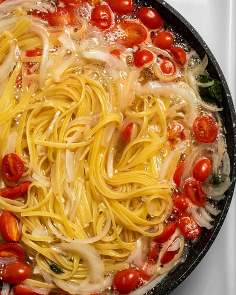 In progress cook with spaghetti noodles, onion, garlic, and cherry tomatoes boiling in water in a cast iron skillet Pan Pasta, One Pan Pasta, Martha Stewart Recipes, Recipe Critic, Stone Farmhouse, Pasta Plates, Spaghetti Noodles, Pasta Pasta, One Pot Pasta