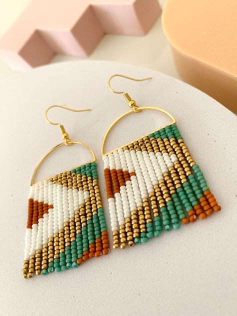 Handmade // Handcrafted  Seed Bead Earrings Bead Colors: Terracotta, Green, Gold, White These handmade earrings are designed and created by Modish. These earrings were designed to create a modern yet boho feel. The earrings start with a handcrafted design and color scheme palette. Then, they are carefully stitched and assembled one bead at a time. The design is stitched with glass seed beads (size 11) on a gold plated half moon // D shape. Ear wires are also gold plated. Each set is handmade. So please note that there could be a slight difference than what is pictured. However, it shouldn't be noticeable. It's just in their handcrafted nature.  Dimensions: approximately 1.30 inches by 2 inches These earrings are lightweight and make a statement! Hope you enjoy! Diy Pearl Necklace, Seed Bead Fringe Earrings, Jewels Diy, Seed Bead Crafts, Earrings Bead, Beaded Earrings Diy, Loom Pattern, Seed Bead Tutorial, Beaded Earrings Patterns