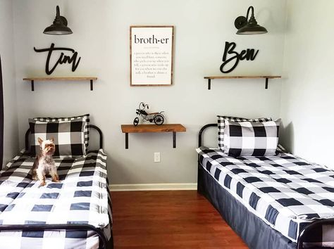 This industrial kids' room features two matching metal bed frames with white and black checkered duvet covers arranged in a small bedroom. Individual overarching black wall lights and wooden shelves with names provide individuality for the two boys that share this space. An additional wooden shelf is mounted in between the beds. Beddys Bedding, Shared Boys Rooms, Grown Up Bedroom, Vintage Kids Room, Kids Shared Bedroom, Gorgeous Bedrooms, Shared Room, Twins Room, Boys Bedding