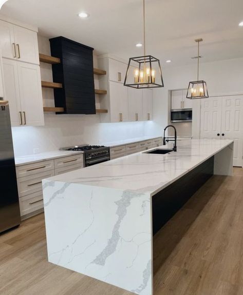 Pin on Kitchen Reno White Kitchen Black Island Modern, Farmhouse Kitchen White Countertops, Farmhouse Waterfall Island, Modern Kitchen Waterfall Island, Bar Stools Kitchen Peninsula, Black Quartz Kitchen Island, Island With Waterfall Countertop, Kitchen Waterfall Island Ideas, Kitchen Island Ideas Waterfall