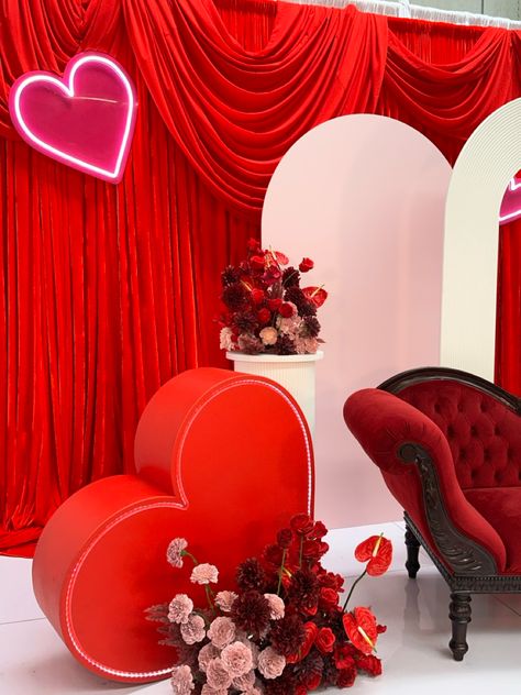 Valentine’s Day styled shoot with red and pink florals, a red loveseat, red light up love heart, and pink and white backdrops Valentine’s Day Photobooth, Wedding Hills, Valentines Pinup, Sv Valentin, Queen Of Hearts Valentines, Flower Foam Diy, Valentines Day Minis, Valentine Brunch, Valentine Photo Backdrop