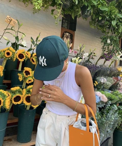 photo of a girl looking down with a flower stand with sunflowers in background. she is wearing a white tank top, white jeans, green baseball hat, and a orange bag. Danie Sierra, Fashion Outfits Ideas, Nyc Fits, Outfits Stylish, Island Outfit, Insta Pictures, Model Aesthetic, Tiktok Style, Current Fashion Trends