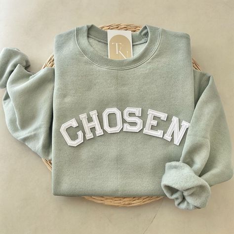 This Chosen crewneck sweatshirt is the perfect trendy minimalistic christian sweatshirt to declare your faith to the Lord! A great for your family, friends, or loved ones. - Sweatshirt is super soft and comfy! ♡  - Sweatshirt composition: 50% cotton, 50% polyester - All our sweatshirts run a unisex fit. They are naturally oversized, so we normally recommend your true size. But if you like a more baggy look, we recommend sizing up. - These letters are iron-on patched and is heat pressed, not embr Patch On Sweatshirt, Cricket Sweatshirt Ideas, Diy Iron On Patches Sweatshirt, Homemade Sweatshirt Ideas, Christian Woman Outfits, Iron On Patch Sweatshirt, Christian Sweatshirt Designs, Chosen Sweatshirt, Sweatshirts Christian