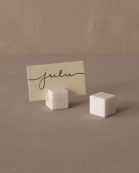 Effortlessly guide your guests to their seats with our Marble Place Card Holder Set. Each piece, crafted from elegant marble, is designed with a slot to hold a name card, adding an unexpected element of sophistication to your event. But its use goes beyond seating arrangements. We like to these holders for displaying cheese types on a serving board, presenting wine varietals during a tasting session, or labeling dishes during a gathering. Their versatility also makes it a perfect gift for the di Wedding Table Decorations Name Cards, Place Markers Wedding, Marble Gift Ideas, Name Holders For Wedding, Stone Place Cards, Ceramic Place Cards, Ceramic Place Card Holders, Unique Name Cards Wedding, Placecards Wedding Table