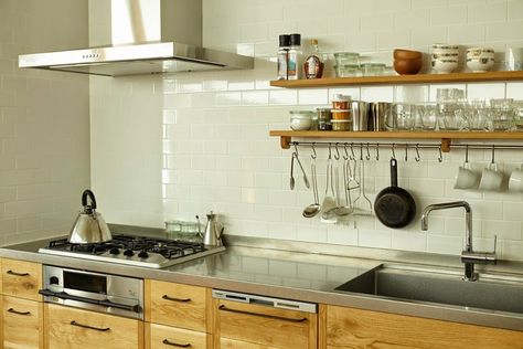 The kitchen has stainless steel counters—made by hand with a vibration finish that gives it a matte, rather than shiny, look—and a backsplash of white subway tile. The millwork conceals a small-scale dishwasher. Note the slim drawer beneath the stovetop: It’s a fish grill, common in Japan in place of a full oven. Japanese Counter, Sunshine Kitchen, Japanese Kitchen Design, Tiny Home Kitchen, Japanese Kitchens, Kitchen Steel, Japanese Style Kitchen, Apartment Rustic, Unfitted Kitchen