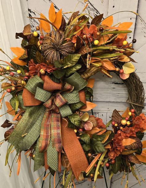 Adorn your door with a beautiful Fall Crescent style Magnolia Wreath, featuring accents in autumnal colors, Seeded Eucalyptus, orange Ficus, and pomegranate berries.  Faux Fall Foliage is artfully arranged on a natural 16-inch grapevine wreath, complemented by a grapevine pumpkin and a bow showcasing four distinct colors.  The wreath boasts high-quality silk green and brown Magnolia stems, eucalyptus in fall hues, along with orange and green filler flowers and orange Ficus leaves. This grapevine wreath has an approximate diameter of 25x25 inches, measured from leaf tip to leaf tip. Thank you in advance for your purchase. I would like if you would follow me on social media as I can be found on Facebook at facebook.com/anothergratefulcreationbyccCustom Wreath Design, and on Instagram - anoth Fall Window Wreaths, Autumn Wreath Ideas, Grapevine Wreath Ideas, Fall Wreath Ideas, Grapevine Pumpkin, Elegant Fall Wreaths, Fall Lanterns, Fall Grapevine Wreath, Wreath With Bow