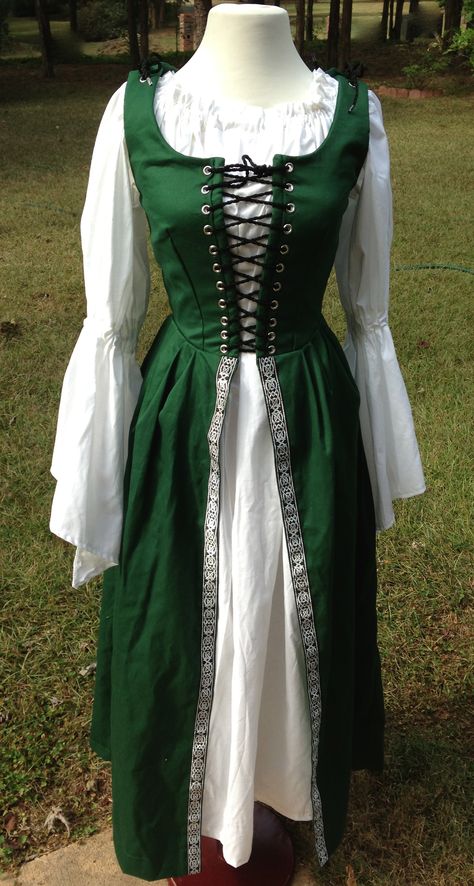 This is one of our Cotton Irish Overdresses with the Celtic Nordic Black and Silver trim added on the skirt. It is machine washable and shown with the white muslin chemise with bell sleeves. Lovely! We also make this is other colors. Irish Fashion Women, Traditional Irish Clothing, Ireland Clothing, Medieval Costume Women, Celtic Dress, Irish Dress, Pirate Dress, Celtic Clothing, Theater Costumes