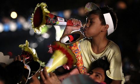 Davao, southern Philippines: A Filipino boy blows his Torotot (party blower) for a new year's attempt to break the Guinness book of World Record for the "Most number of people blowing party blowers simultaneously". Photograph: Ritchie B. Tongo/EPA Filipino New Year, Party Blower, Cavite City, Party Blowers, Haha Photos, Philippines Culture, New Years Traditions, Celebration Around The World, Davao City