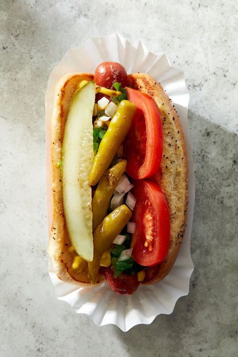 A proper Chicago dog is an all-beef frankfurter (such as Vienna Beef) in a poppy seed bun, topped with yellow mustard, neon-green sweet pickle relish, chopped white onion, tomato slices, a dill pickle spear, pickled sport peppers, & celery salt. If you can’t find Chicago-style sport peppers, then sliced pepperoncini works in a pinch. Don’t skip the celery salt; its herbal lightness makes these dogs shine. And don't even think of putting ketchup on it 😁 Chicago Hot Dog Recipe, Chicago Dogs, Plum Dessert, American Chinese Food, Hot Beef Sandwiches, Desserts Drinks, Chicago Style Hot Dog, Dog Restaurant, Chicago Hot Dog