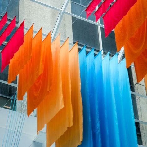 Hanging sunburst fabric installation for the Textile LA show. This colorful art piece hangs from the ceiling of the California Market Center lobby. Corrie in Color is a creative studio specializing in custom event decoration and art installations that bring events and interiors to life. #textileinstallation #backdrop #experiential #design Fabric Art Installation, Ceiling Art Installation, Experiential Graphics, Fabric Installation, Fabric Ceiling, Ceiling Art, Stage Set Design, Hanging Fabric, Exhibition Stand Design