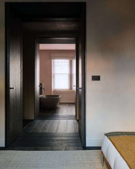 Glimpsing the bath from the bedroom highlights the twin double door openings integrated into the dressing room joinery. The solid oak doors are finished to match the flooring, the direction of which changes to further emphasise the dark timber openings. Hats off to both @reclaimedflooringco and @westhillprojectsltd for pulling off some demanding detailing! #design #architecturelovers #architecturedesign #archilovers #architectureinspiration #architecturelover #architecturedaily #architec... Dark Oak Flooring Bedroom, Oak Flooring Bedroom, Dark Timber Flooring, Dark Oak Flooring, Flooring Bedroom, Door Openings, Solid Oak Doors, Oak Flooring, Oak Doors