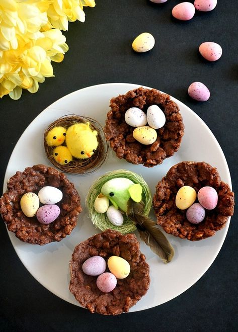 Overhead shot of a white plate with 4 rice krispies nests and 2 bird nests, mini Cadbury eggs and flowers around the plate Easter Egg Rice Crispy Treats, Easter Nests Recipe, Rice Krispie Nests, Easter Rice Krispie Treats, Easter Egg Nest, Chocolate Rice Krispies, Cocoa Krispies, Easy Easter Treats, Easter Nests