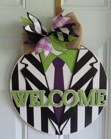 Beetlejuice Halloween Door Hanger Bring a touch of spooky fun to your Halloween decor with our 16" Beetlejuice Halloween Door Hanger. Inspired by the iconic character, this door hanger is sure to add a playful and eerie vibe to your home, delighting guests and trick-or-treaters alike. #DoorDecor #doorsign #frontporch #halloween #moviedecor https://www.maker-mall.com/beetlejuice-halloween-door-hanger/ Halloween Pumpkin Door Hanger, Beetlejuice Door Decor, Painted Wood Door Hangers, Beetlejuice Door Hanger, Diy Halloween Door Hanger, Beetlejuice Halloween Decorations Diy, Beetlejuice Wreath, Beetlejuice Sign, Beetlejuice Decor