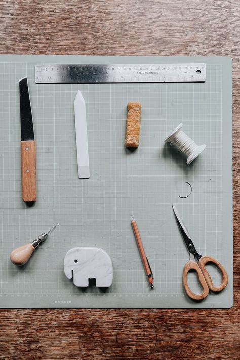 Overhead view of bookbinding tools and supplies: shoe knife, steel ruler, teflon folder, beeswax, linen thread, curved needle, scissors, mechanical pencil, elephant shaped marble weight, awl Bookbinding Aesthetic, Bookbinding Studio, Bookbinding Supplies, Bookbinding Tools, Bookbinding Tutorial, Product Branding, Linen Thread, Life Vision, Bone Folder