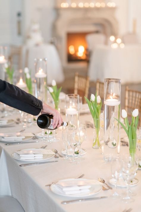 White tulips and floating candles for a simple yet classic long tablescape. Photography: @julianatomlinsonphotography Venue: @parkchateau Flowers: @leighflorist #parkchateau #estatewedding #leighflorist #weddingflowers #weddingflorist #bridalbouquet #boutonniere #njweddingflorist #phillyweddingflorist #januarybride #januarywedding #winterbride #winterwedding #tulips Tulips Table Setting, Tulips And Candles Centerpiece, Tulip Centerpieces Wedding Diy, Tulip Table Decorations, White Tulips Centerpiece Wedding, Simple Tulip Centerpieces, All White Party Table Centerpieces, White Tulip Table Decor, Floating Candles Tablescape