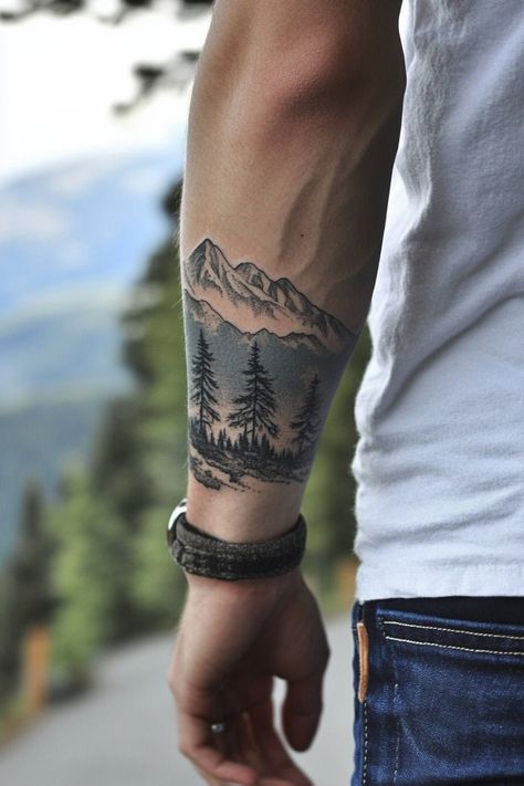 Forearm tattoo of a mountain landscape with trees. Tattoo Arm Cover Up For Men, Nature Bicep Tattoos For Men, Top Of Bicep Tattoo Men, Mountain Tattoo American Traditional, Simple Nature Tattoos Men, Men’s Mountain Tattoo, Cool Upper Arm Tattoos, Arm Cover Up Tattoos Men, Hiking Tattoo For Men