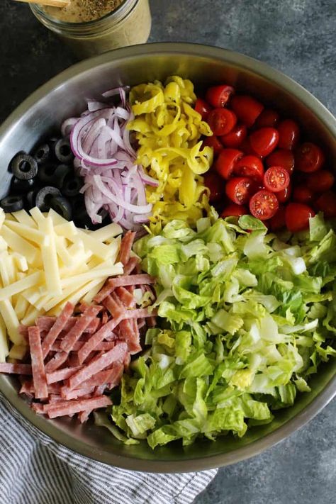 Italian Chopped Salad from afarmgirlsdabbles.com - an Italian salad loaded with fresh goodness, plus salami, provolone, pepperoncini, and olives. It's light, yet hearty, and extra flavorful with a zippy Italian vinaigrette! #salad #italian #chopped #lettuce #tomatoes #onion #salami #provolone #pepperoncini #olives Italian Vinaigrette, Salade Healthy, Thanksgiving Fruit, Easter Fruit, Italian Salad Recipes, Salad Buah, Italian Chopped Salad, Vinaigrette Salad, Resep Salad