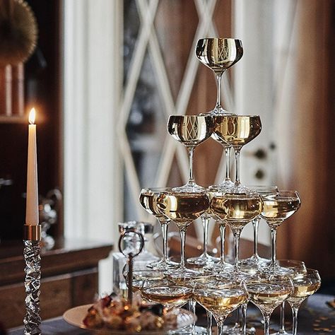 We show you how to build a champagne tower for your New Year's eve party! Follow our step-by-step guide and create a tower that is sure to please your guests. Glitz And Glam Holiday Party, Elegant New Years Party, Great Gatsby Christmas Party, Luxury Birthday Dinner, New Year's Eve Decor, Estilo Charleston, Honolulu Wedding, Nye Decorations, Holiday Lookbook