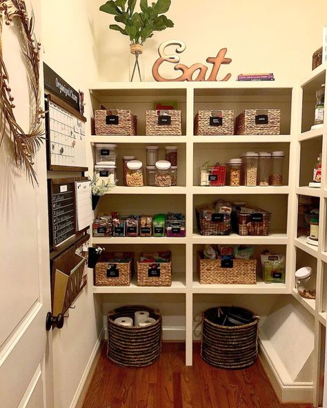 White door with black door knob is opened to reveal a walk in pantry with stained wood flooring. The pantry is fitted with white built-in shelves holding wicker baskets and clear plastic snack containers. Black Door Knob, Walk In Pantry Ideas, White Pantry, House Pantry, Built In Pantry, Wooden Step Stool, Pantry Remodel, White Shiplap Wall, White Floating Shelves