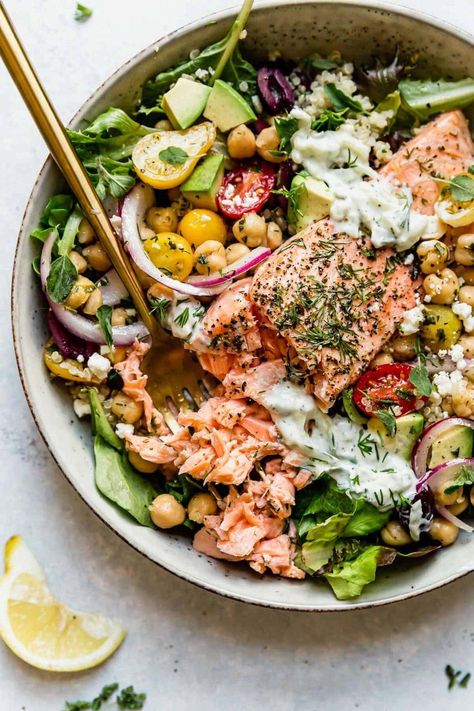 A healthy quinoa bowl complete with lemon-herb marinated salmon, garbanzo bean salad, tender quinoa, crisp greens, feta cheese, kalamata olives, and topped with homemade Tzatziki. This Mediterranean Bowl with Salmon is hearty, healthy, delicious, and makes for the perfect prep-ahead meal. It's a balanced bowl including a great source of quality protein, healthy fats, and fiber. || The Real Food Dietitians || Garbanzo Bean Salad, Mediterranean Bowl, Salad Bowl Recipes, Garbanzo Beans Salad, Clean Dinner Recipes, Mediterranean Bowls, Salmon Quinoa, Real Food Dietitians, Garbanzo Bean