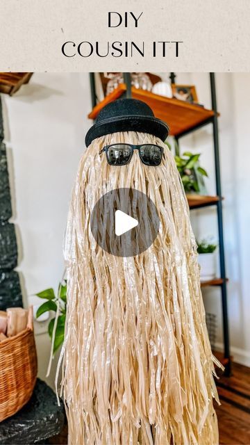 Jessica Cole on Instagram: "This was a hit last year! Super easy (and cute) DIY Cousin ITT! I’m still feeling under the weather, so I enlisted the help of Mia for this simple DIY!   Supplies:  1- tomato cage  1- small lamp shade (I used one laying around the house)  1- hula table skirt 1- Bowler Hat (party city)  1- pair of shades  1- zip tie/ hair tie   Directions: 1) place the tomato cage upside down and zip tie the ends together.  2) place lap shade on top ( I used a little packing tape to hold in place)  3) wrap the table skirt around the cage, working your way to the top. I secured the top by stapling it to the lamp shade.  4) place hat and shades on cousin ITT!   That’s it!! You can add lights underneath for an eerie effect.   #diy #diyhalloween #diyhalloweendecorations #diyhalloween Tomato Cage Crafts, Cousin Itt, Lamp Shade Crafts, Small Lamp Shade, Dollar Tree Halloween Decor, Halloween Lamps, Small Lamp Shades, Hat Party, Feeling Under The Weather