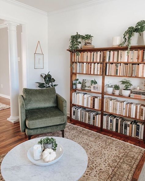 the round coffee table not only adds much needed mass to the center of the room to balance out the bookshelf and chair, but it adds a contrasting shape to the rectilinear bookshelf. Reading Area In Office, Bookshelf In Office, Reading Area Ideas, Big Bookshelf, Bookshelf Dimensions, Books And Plants, Lots Of Books, Modern Boho Living Room, Deco Studio