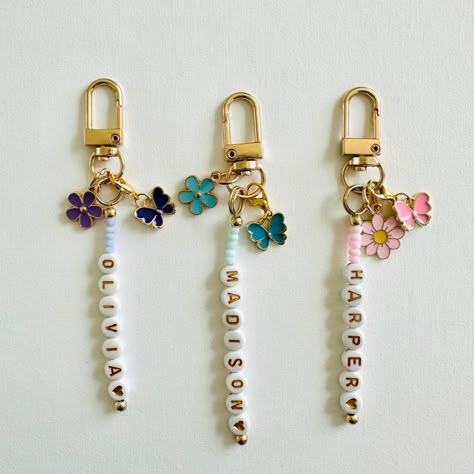 Elevate your everyday essentials with our personalized keychains, available in purple, blue and pink!  Not only do these adorable keychains add a pop of color to your keys, backpack, purse, or any accessories, but they also offer a unique touch with your personalized name. The butterfly charm is detachable, allowing for versatile styling options.  What to add more flair?  Explore our charm collection and customized your keychain with additional charms to truly make it your own. Also, you can upg Bead Name Keychain, Diy Beaded Keychain Ideas, Keychain Ideas Clay Beads, Keyring Charms, Personalized Keychain Diy, Name Bead Keychain, Key Chains Beads, Custom Key Chains, Charm Keychains