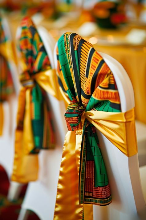 Transform your wedding venue into a cultural haven with vibrant Kente cloth chair sashes. Perfect for an Afrocentric celebration, these sashes add a touch of heritage and style. 🌍💒🎉 Celebrate love with a traditional twist! #WeddingInspiration #AfricanWedding #KenteDesign #WeddingDecor #AfrocentricWedding #CulturalElegance #ChairSashes #WeddingDetails Jamaican Theme Wedding Ideas, Coming To America Wedding Theme, African Centerpieces Ideas, Chair Sash Ideas Wedding, African Wedding Theme Decoration, African Wedding Decor, African Traditional Wedding Decoration, 60th Birthday Party Themes, Wedding Accessories Photography