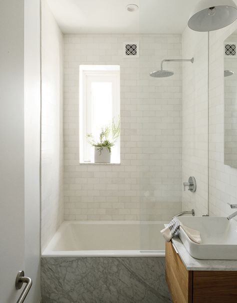 guest bath. All of the apartment’s fixtures are by Kohler, including the kitchen sink and faucet as well as the Tea-for-Two bathtub, Vox square sink, and Catalan mirror in the bathroom. The Thassos marble subway tile is by Ann Sacks. Bathtub Shower Combo, Small Bathtub, Bathroom Tub Shower, Bathtub Remodel, Bathroom Tub, Tiny Bathrooms, 아파트 인테리어, Small Bathroom Design, Tub Shower Combo