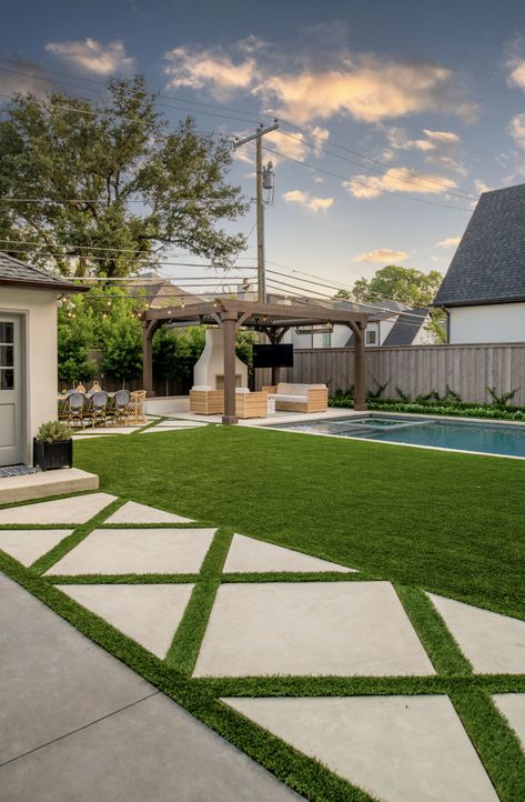 Featuring luxurious grass-cut concrete pavers, a serene grass-line pool, inviting outdoor fireplace, and chic al fresco dining area, our design seamlessly blends sophistication with Southern charm. Dive into poolside elegance and elevate your outdoor living experience today. #HamptonsPool #HamptonsGarden #GrassCutConcretePavers #OutdoorLiving #PoolsideParadise #AlFrescoDining #OutdoorDesign #DallasLandscape Grass And Pavers, Pool With Grass Surround, Fake Grass Pool Area, Concrete And Fake Grass Backyard, Grass And Pavers Backyard Ideas, Pavers Around Pool, Fake Grass Backyard, Hamptons Pool, Hamptons Garden