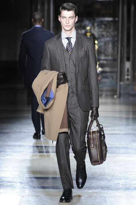 This is Hackett London men's RTW fall 2014 collection. The model is dressed up with pinstriped suits, holding wool coat on right arm and holdall on left hand. It seems like he is ready to go for the business trip and grey suits with leather gloves and oxford shoes make the look very professional and elegant. Roaring 20s Men, 20s Men, Gloves Outfit, Grey Suits, London Men, Hackett London, Pinstripe Suit, Plus Ultra, Suits And Jackets