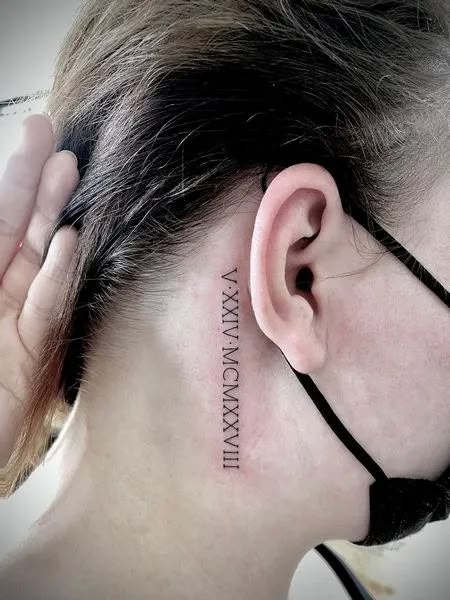 Roman Numeral Neck Tattoo Roman Numeral Tattoo Back Of Neck, Birthdate Neck Tattoo, Roman Numerals On Neck, Roman Numeral Ear Tattoo, Behind The Ear Roman Numeral Tattoo, Roman Numeral Tattoo Men Behind Ear, Number Neck Tattoos Women, Roman Numeral Neck Tattoos Women, Roman Numeral Tattoo For Women