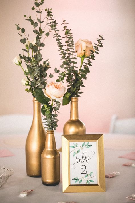 Gold Painted Bottles Centerpiece Ideas, Elegant Wine Bottle Centerpieces, Boho Bottle Centerpieces Wedding, Champagne Theme Centerpieces, Spray Painted Bottles Centerpieces, Turning Wine Bottles Into Vases, Easy Gold Centerpieces, Gold Spray Painted Wine Bottles, Wine Bottle Party Decorations