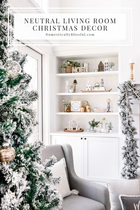 A Neutral Living Room Christmas Decor home tour with flocked garland, a flocked Christmas tree, and a cozy glider by the fireplace to snuggle up in and read Christmas stories. | Two-story living room decorations. | White living room Christmas decorations. | White built-ins with Christmas decorations. | How to decorate bookshelves for Christmas. | Two-story fireplace decor. | Christmas garland on a fireplace mantel. | Large mirror above a fireplace. | Simple Christmas decor. Neutral Pink Christmas Decor, Built In Christmas Decorations, Fireplace Built Ins Christmas Decor, Built Ins Decorated For Christmas, Winter Built In Decor, Christmas Fireplace Shelves Decor, Christmas Decor Ideas For Built Ins, Christmas Decor On Built In Shelves, Built In Shelf Christmas Decor