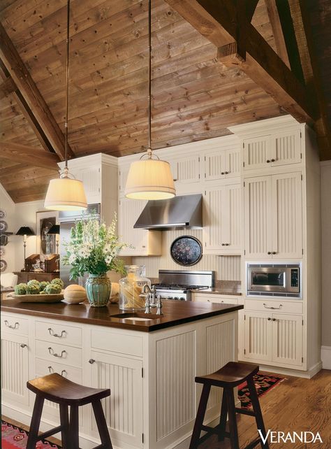 This rustic kitchen features a sloped wooden ceiling leading to beadboard cabinets and island with chopping-block top, all by Wood-Mode.   - Veranda.com Beadboard Cabinets, Wooden Ceiling, Farmhouse Kitchen Cabinets, Wood Ceiling, Cabin Kitchens, Rustic Farmhouse Kitchen, Wooden Ceilings, Wood Ceilings, Cottage Kitchen